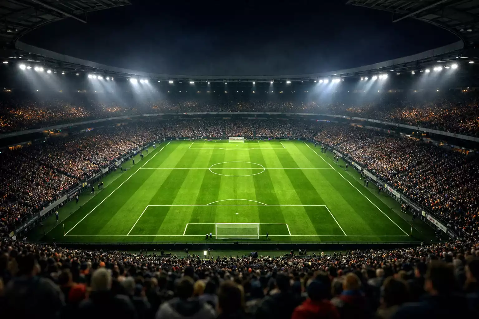 Panoramica dello stadio di calcio italiano durante una partita serale con luci accese