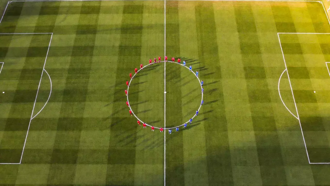 Campo di calcio in erba visto dall'alto con le linee bianche del centrocampo ben visibili